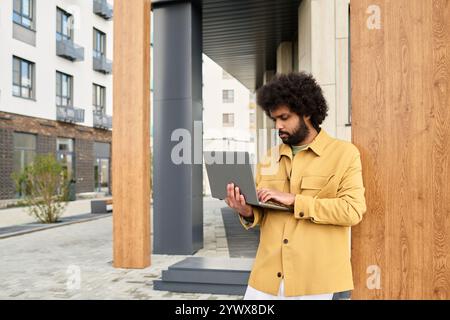 Using Laptop on Urban Street Near Modern Buildings Stock Photo