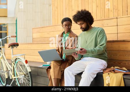 Collaborating on Outdoor Wooden Steps Using Gadgets Stock Photo