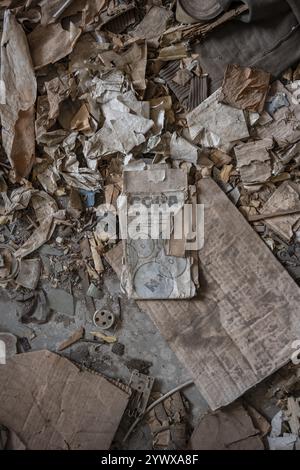 Rubbish and old instructions in Cyrillic script, abandoned destroyed room in a residential building, Soviet apartment blocks, ghost town, Engilchek, T Stock Photo