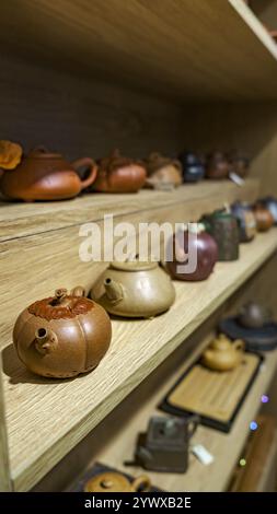 A stunning collection of artisan teapots displayed beautifully on a rustic wooden shelf Stock Photo
