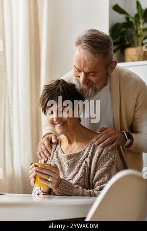 A loving couple enjoys each others company over warm drinks while relaxing indoors. Stock Photo