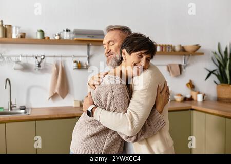 Two seniors express love and affection while hugging in a bright, inviting kitchen. Stock Photo