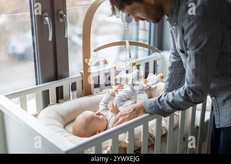 Father on paternity leave looking after his infant son at home Stock Photo