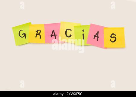 Gracias single word handwritten on colored sticky papers on a white background with copy space (trad. thank you) Stock Photo