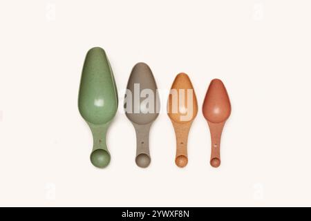 Colored plastic measure spoons on a white bakground with copy space Stock Photo