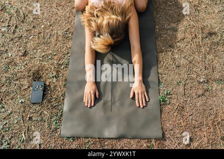 Unrecognizable Young Woman Practicing Yoga Outdoors. Top View. Stock Photo