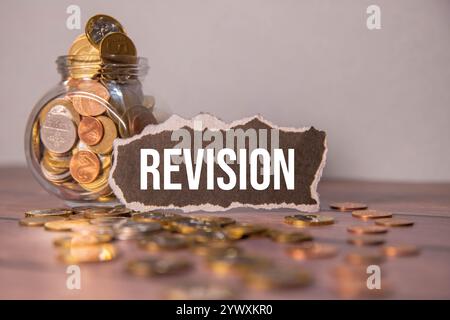 On a light background, multi-colored arrows, black glasses, a green notebook with a pen and a white card with the text REVISION Stock Photo