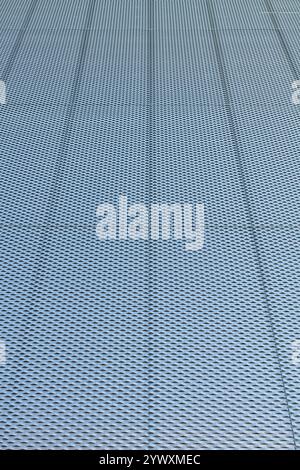 Closeup of metal mesh on concrete wall background texture. Stock Photo