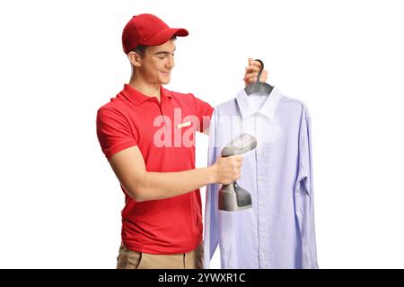 Young male worker ironing a shirt with a hand steam iron isolated on white background Stock Photo