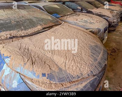 Numerous cars covered in mud and debris after severe flooding in Stock Photo