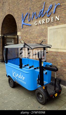 Stint electric cart at a Kindergarden nursery in Amsterdam. Portrait format. Vehicle is empty. Safety belts and logos visible. Stock Photo