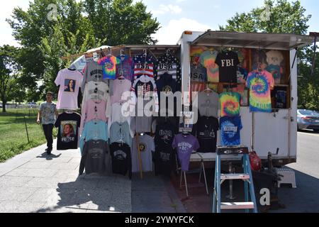 A mobile clothing stall selling a variety of t-shirts, including ones with "USA", "FBI", and political designs, in Washington D.C., USA Stock Photo