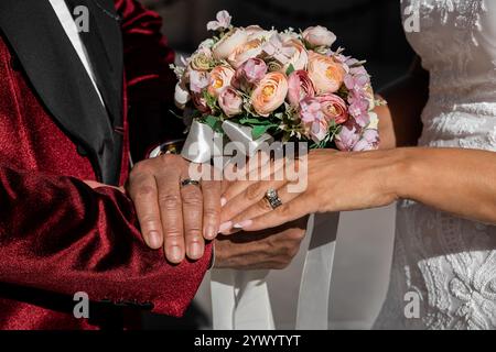 Closeup of bride and groom holding hands and showing rings on Wedding day, special occasion - Image Stock Photo