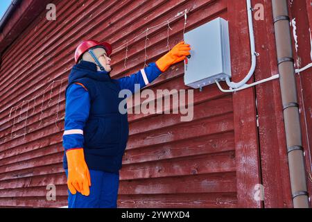 Utility electrician inspects outdoor electrical equipment in rural areas. Stock Photo