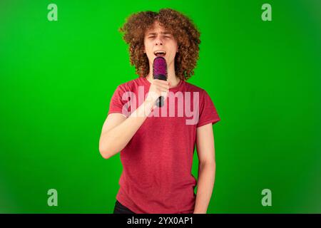 A young guy with curly hair sings in a comb. Hair care concept. Stock Photo