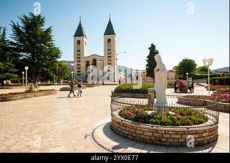 Medjugorje Sanctuary in Bosnia and Herzegovina. In the foreground is the vigin Mary statue and in the background is the parish church. Stock Photo