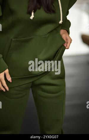 Close up view of green tracksuit, woman with hand in pocket, showcasing sweatpants texture, casual fashion comfort concept Stock Photo