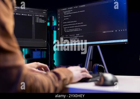 Teleworking cybersecurity administrator using computer to look for security vulnerabilities. IT technician typing on keyboard, installing safeguard code on PC to prevent cyber attacks, close up Stock Photo