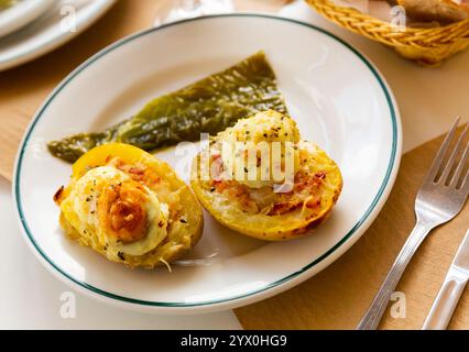 Twice baked potatoes stuffed with meat, jam, cheese and egg Stock Photo