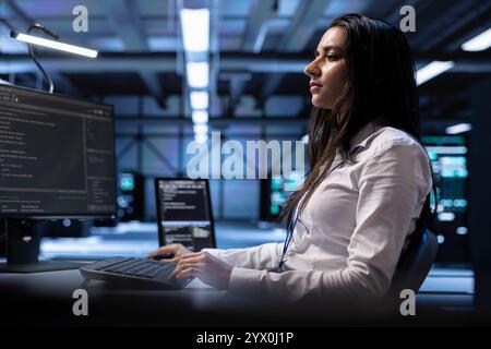 Developer using computer to troubleshoot hardware and software issues in server room. IT professional monitoring and maintaining server and network infrastructure in data center using PC Stock Photo