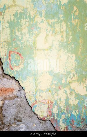 Textured wall that is crumbling tinted in yellow and light green Stock Photo