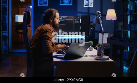Developer pressed by deadline, drinking coffee and doing multitasking to finish developing PC code. Caffeinated IT specialist solving database error using multiple desktop and laptop screens, camera B Stock Photo