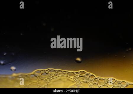 Bright bubbles at the bottom of the picture, minimalistic background, Yellow bubbles on black background, liquid abstraction Stock Photo