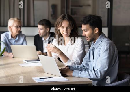 Two businesspeople discussing new project using laptop Stock Photo
