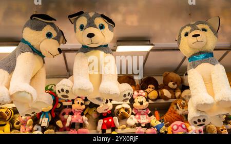 Giant stuffed animal dog toy prizes hanging on funfair fairground stall booth Stock Photo