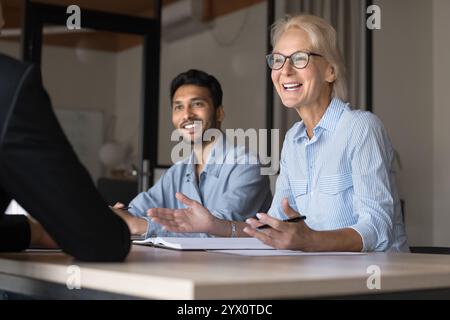 Business professionals engaged in lively and positive conversation during meeting Stock Photo