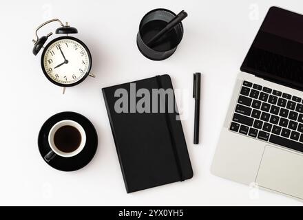 Trendy layout made with computer, notebook, pens, alarm clock and cup of coffee on white background. Minimal business concept. Creative office objects Stock Photo