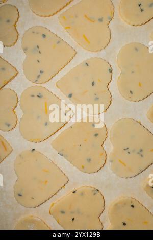 lemon thyme shortbread cookie dough in heart shapes on baking parchment paper Stock Photo