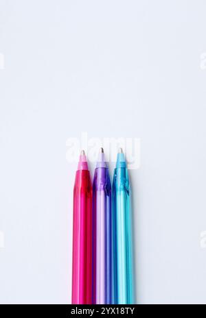 Three ballpoint pen in cool color on vertical white background with copy space. Creative stationery, school supplies, drawing lesson, content creation Stock Photo