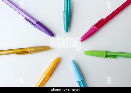 Colorful pens arranged in circle on white background. Bright color stationery school supplies. Creativity, art, imagination concept. Stock Photo