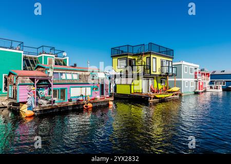 A row of colorful houses are floating on the water. The houses are brightly colored and appear to be small Stock Photo