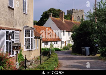 Old Guildhall, now terrace cottages, and St Mary and St Clement Church along lane in Clavering, Saffron Walden, Essex, England, UK Stock Photo