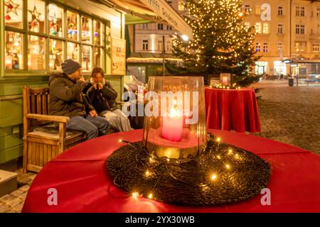 Vorweihnachtliche Stimmung am Wiener Platz, Besucher trinken heißen Glühwein in der Kälte, München, Dezember 2024 Deutschland, München, Dezember 2024, weihnachtliche Stimmung am Wiener Platz, Besucher trinken Glühwein am Marktstand Wein trifft Schokolade, festlich geschmückte Tische mit Kerzen laden zum Verweilen ein, die Lichter des Christbaums leuchten in den Abendhimmel, Weinhandlung, Markt am Wiener Platz in Haidhausen, es ist kalt am frühen Abend, Weihnachtszeit, Adventszeit, Winter, Bayern, bayerisch, *** Pre-Christmas atmosphere at Wiener Platz, visitors drink hot mulled wine in the col Stock Photo