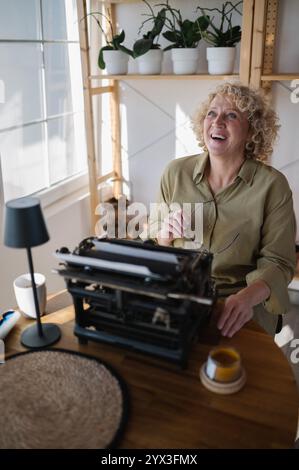 Smiling businesswoman working with a typewriter in her home offi Stock Photo