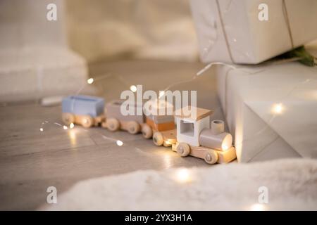 Toy train next to presents and twinkle lights Stock Photo