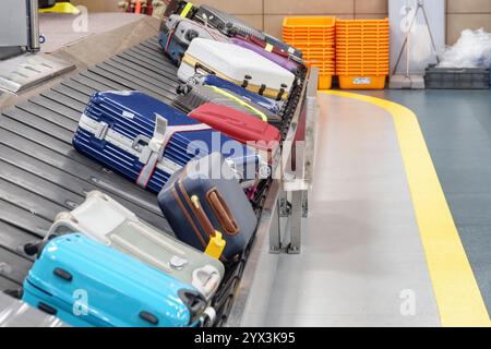 Blue suitcases on luggage conveyor belt in airport Stock Photo