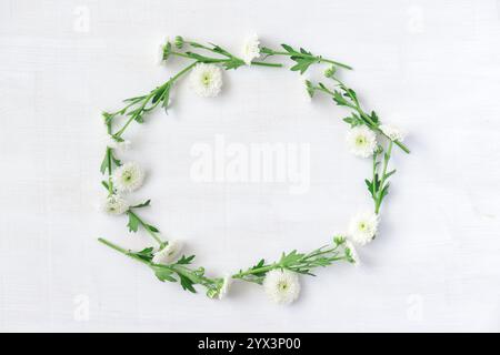 Scenic wreath of white flowers on white wooden background Stock Photo