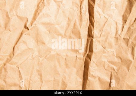 Crumpled beige paper texture. Wrinkled surface, abstract background. Stock Photo