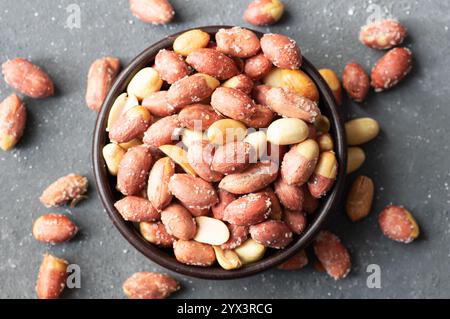 Roasted salty peanut without Shell in bowl or burlap sack on rustic background, concept of nuts Stock Photo