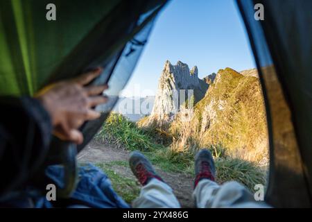 Man camping in Appenzell Alps, view from inside the tent. Eco tourism in Switzerland. Stock Photo