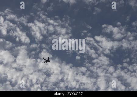 Cirrocumulus white clouds in a blue sky with a jet aircraft flying below, England, United Kingdom, Europe Stock Photo