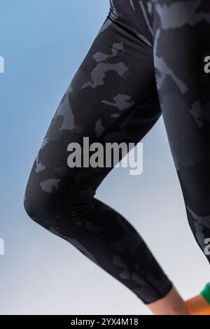 Close-up detail of black camouflage leggings, showcasing the unique pattern and texture of the fabric Stock Photo