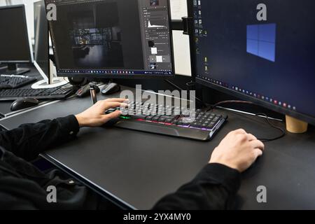 Editing photo on computer by a graphic designer using software for creative work, shown with dual monitor setup, digital art concept Stock Photo