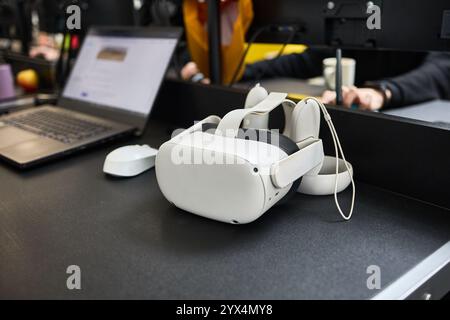 On modern office desk, a virtual reality headset and laptop, technology workspace, innovative tech concept Stock Photo