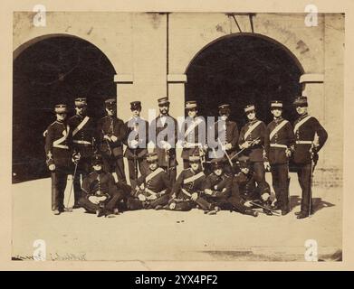 Holdich's Term, about 1857-1859. Group portrait of military students as Addiscombe Seminary. The young men are arranged in two rows with the first row of students seated on the ground. The group is posed in front of two arched entryways. Stock Photo