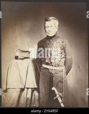 Lt. General Sir J. Burgoyne, G.C.B., 1855.  Additional Info: Portrait of a man standing with his hands behind his back in military attire with a hat place on a table standing next to him. Stock Photo